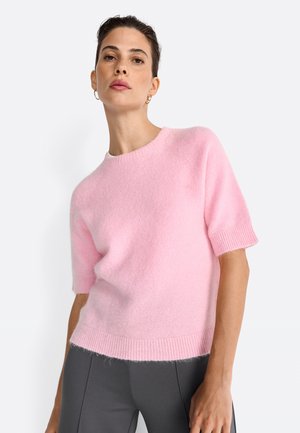 Maglione a maniche corte in rosa pallido, con scollo rotondo e orlo a coste. Il tessuto appare morbido e leggero.