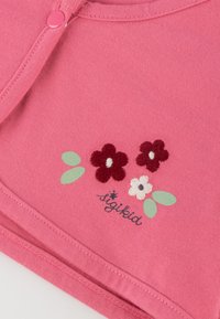 Rosa Baumwollbekleidung mit gestickten Blumenmustern in Rot, Weiß und Grün, mit einem Knopfverschluss am Halsauschnitt und einem genähten Saum.