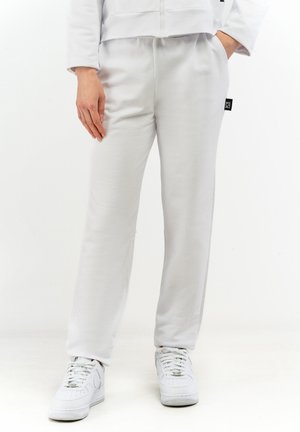 Hellgraue Sweatpants aus weichem Stoff, mit lockerer Passform und elastischem Bund. Mit einem kleinen Markenetikett an der Seite.