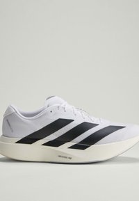 Weißer Laufschuh mit schwarzen Streifen und dicker Sohle, beschriftet mit Lightstrike Pro, von der Seite auf neutralem Hintergrund dargestellt.