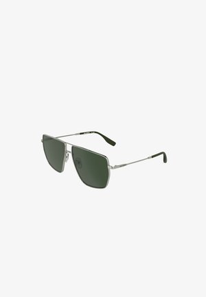 Lunettes de soleil à verres rectangulaires vert foncé avec une fine monture en métal argenté et des embouts de branches noirs, vue en angle montrant les plaquettes de nez et le détail de la marque.