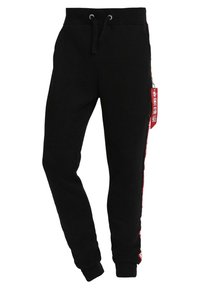 Svarta joggers i mjukt tyg med dragsko i midjan, smalnande mudd, sidofickor och en röd detalj med text på ena sidan.