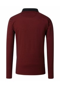 Koszulka polo z długim rękawem w głębokiej czerwieni z czarnym kołnierzykiem. Posiada teksturowaną tkaninę i prosty dół. Prosty i klasyczny fason.