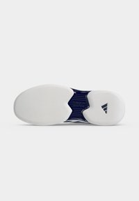 Semelle d'une chaussure de sport blanche avec un support noir "TORSION SYSTEM" et un logo Adidas noir sur la zone du talon.