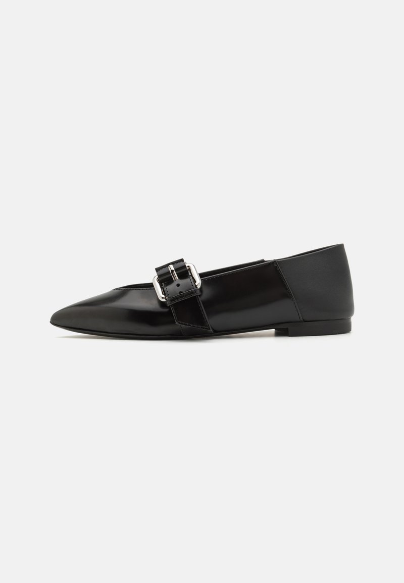 Black patent leather flat shoes with pointed toe, featuring a decorative buckle strap on the upper and a low, rounded heel.
