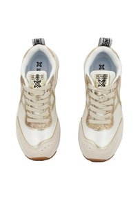 Sneaker bianche con un'accoppiatura beige testurizzata, dotate di un logo oro metallico, punta tonda e lacci spessi. Una linguetta decorata è posizionata sul retro.
