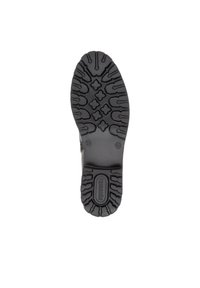 Suola di scarpa in gomma nera con modelli testurizzati per la presa, che includono una serie di forme rialzate e un'area centrale per il logo.