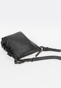 Svart läder crossbody-väska med dragkedjestängning, platt form, texturerad yta och justerbar rem med metallackcenter.