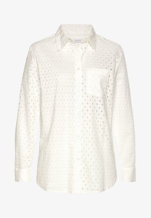 Valkoinen pitkähihainen paita, jossa napillinen edessä, teksturoitu kangas, jossa on leikattuja ympyräkuvioita, ja yksi rintatasku.