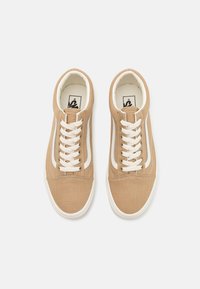 Brune lær-sneakers med hvite detaljer, flate lisse og rund tå. Har kontrasterende sidestripe og polstret krave.