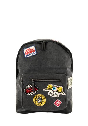 Zaino in tessuto nero con vari patch ricamati. Presenta una tasca con zip sul davanti e una parte superiore arrotondata, con spallacci robusti.