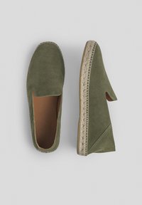 Zapatos verdes de ante tipo slip-on con una suela de esparto, presentan un acabado texturizado y un diseño de lado abierto. Se puede ver un suave forro interior.