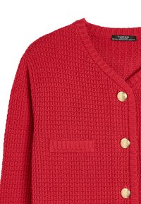 Czerwony sweter zapinany na guziki z dzianiny o textured wzorze, z dekoltem w kształcie V, złotymi guzikami i jedną kieszonką na piersi. Żebrowane mankiety i dół.