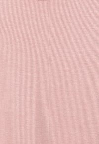 Top in tessuto a coste di un rosa pallido, caratterizzato da una consistenza morbida e un colletto rotondo. Il design è aderente con linee verticali.