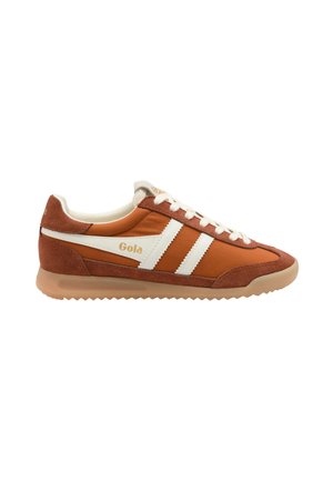Baskets Gola marron et blanches avec lacets blancs, deux bandes blanches sur le côté, accents en daim et semelle beige à motif zigzag.