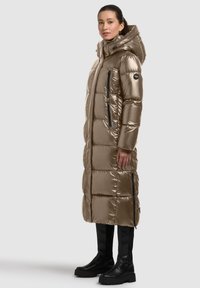 Metallic gold puffer coat with a long design, side zip pockets, and a hood. Features a quilted texture and black hardware accents.