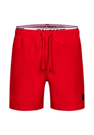 Costume da bagno da uomo rosso con elastico in vita, coulisse regolabile e etichetta del marchio nera sulla gamba inferiore destra.