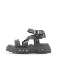 Sandalias de plataforma negras con tiras cruzadas, correa de tobillo ajustable y acentos de hardware plateado. Hechas de material sintético con suela texturizada.