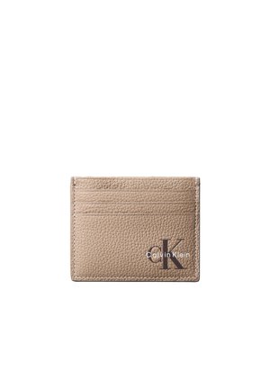 Beige gestructureerde leren kaarthouder met drie kaartsleuven en zwart Calvin Klein-logo in de rechterbenedenhoek.