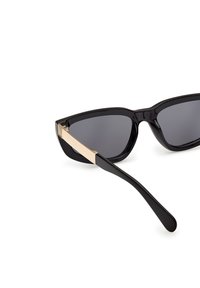 Ochelari de soare cat-eye negri, cu lentile întunecate și un accent strălucitor de ton aurit pe tâmpla neagră. Ramă din plastic neted și design elegant.