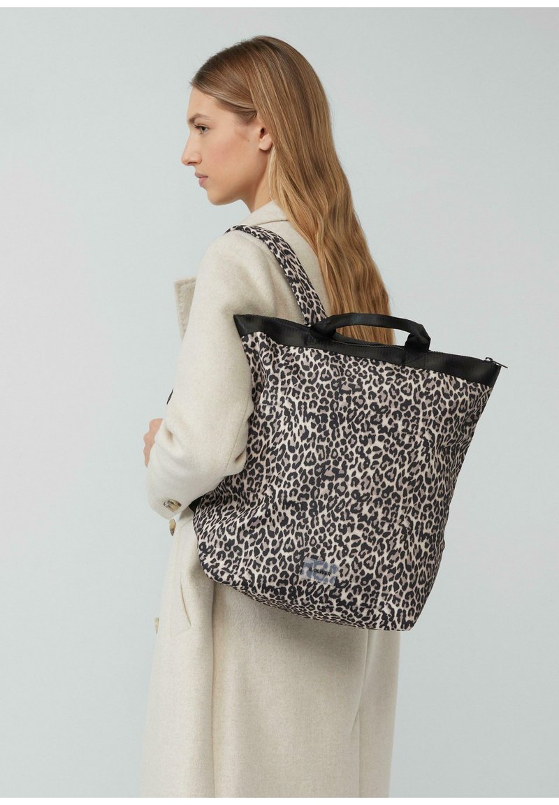 Sac fourre-tout en imprimé léopard avec un contour noir, de forme rectangulaire, deux poignées solides, fabriqué en tissu doux et texturé.