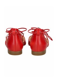 Bailarinas de cuero rojo con punta redonda, suela plana, estilo de atado con lazos y remaches decorativos a lo largo del tacón.