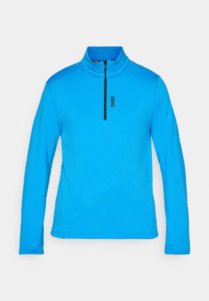 Modrý pulóver s dlhým rukávom a vysokým golierom, ktorý má čierny zips a malé čierne logo na hrudi. Hladká, ľahká tkanina.