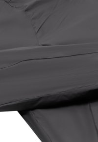 Juodas, lygus audinys su šiek tiek blizgiu paviršiumi, turintis sulenktą dizainą ir subtilius siūlus, sukuriantį sluoksniuotą išvaizdą.