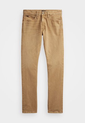 Pantalon chino en coton beige avec une coupe droite. Comprend cinq poches, une braguette zippée et une fermeture par bouton en métal. Texture lisse.
