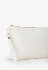 Witte textuur tas met een bloemen reliëfpatroon, gouden hardware en een afneembare schouderband. Ritsluiting aan de bovenkant.