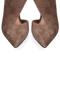 Bruine suède hakken met een spitse neus en een open zijuitsnede. Gladde textuur, minimalistisch ontwerp, geschikt voor formele of casual kleding.