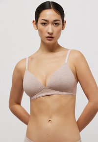 Bralette triangular de algodón en color rosa claro, con tirantes ajustables y dobladillo con forma de pico. Textura suave sin relleno ni aros.