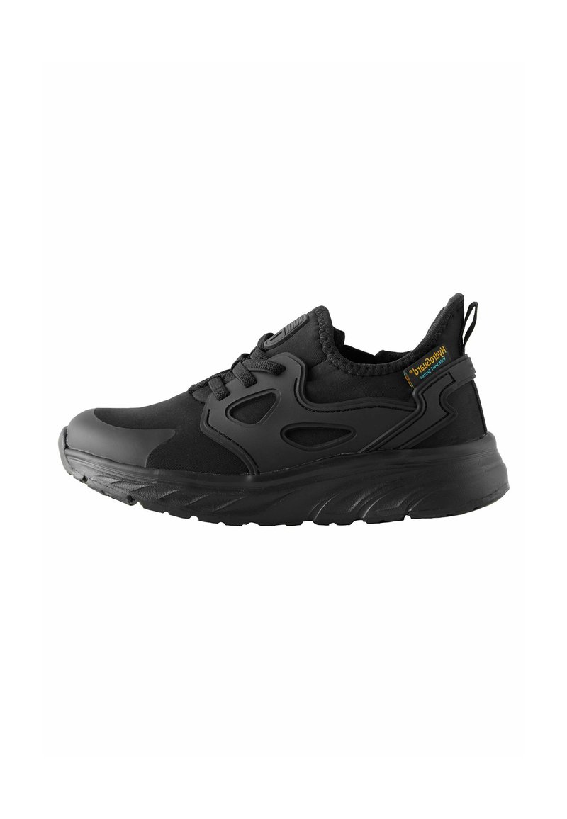 Chaussure de sport noire avec une tige en textile, semelle en caoutchouc flexible et accents en maille. Comprend une languette de traction et un design minimaliste.