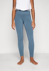 Blaue Leggings aus einem weichen, dehnbaren Stoff mit hohem Bund. Glatte Textur und schmale Passform, die knapp über den Knöcheln endet.