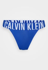 Blauwe Calvin Klein thong met een brede elastische tailleband met witte logo tekst. Glad materiaal, driehoekige vorm, minimalistisch ontwerp voor beperkte bedekking.