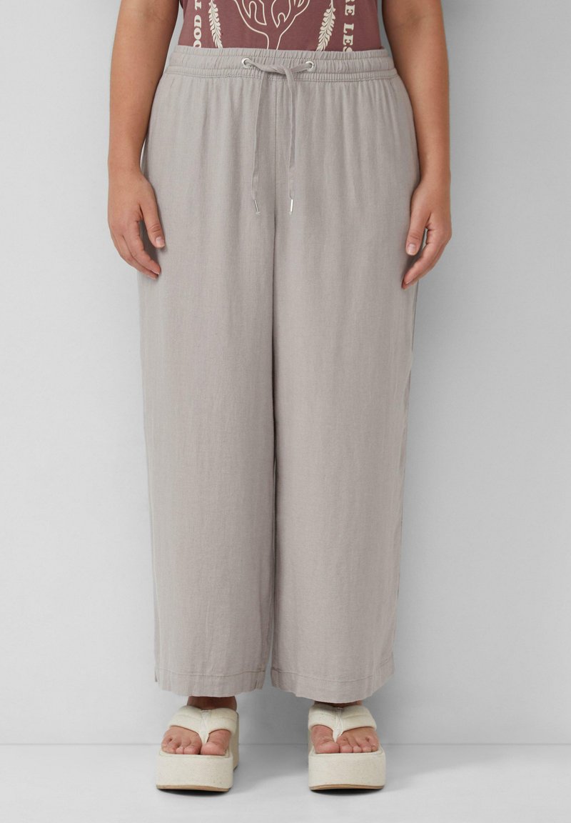 Lichtgrijze wijde broek met een elastische tailleband en een trekkoord. Het materiaal lijkt zacht en lichtgewicht, met een subtiele textuur.