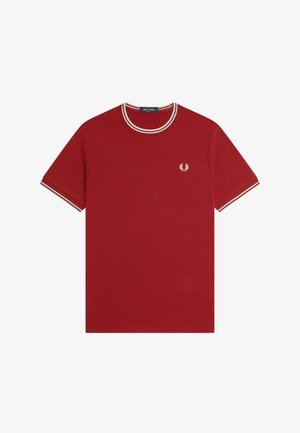 Camiseta roja de manga corta con dobles rayas blancas en el cuello y puños, y pequeño logo de corona de laurel blanca en el pecho izquierdo.