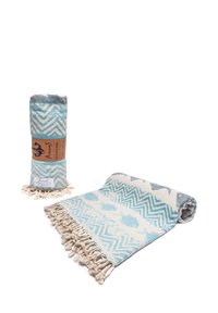 Blue and white fish-patterned peshtemal towel with fringed edges, shown rolled and partially unrolled on a white background.