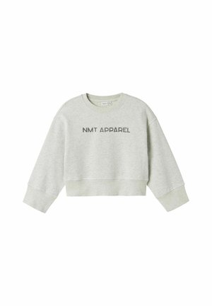 Gaiši pelēks īsais džemperis ar garām piedurknēm, ar uzrakstu "NMT APPAREL" tumšākā pelēkā krāsā uz priekšpuses. Mīksta kokvilnas maisījuma tekstūra.