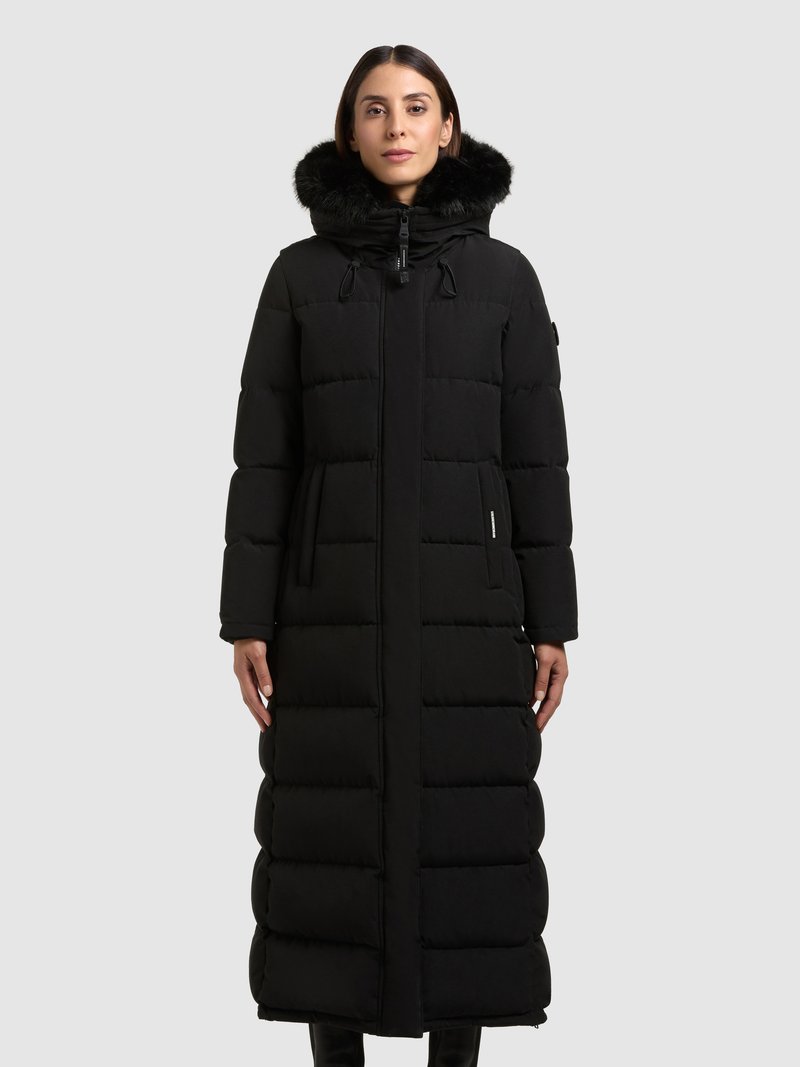 Dlhý čierny prešívaný kabát s kapucňou so srsťou, ktorý má prešívané sekcie, zips a bočné vrecká pre funkčný dizajn.