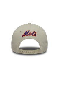 Μπεζ καπέλο με επίπεδη γείσο και ρυθμιζόμενο λουράκι. Διαθέτει μπλε και πορτοκαλί κεντημένο λογότυπο "Mets" στο κέντρο του πίσω μέρους. Υφασμάτινη υφή.