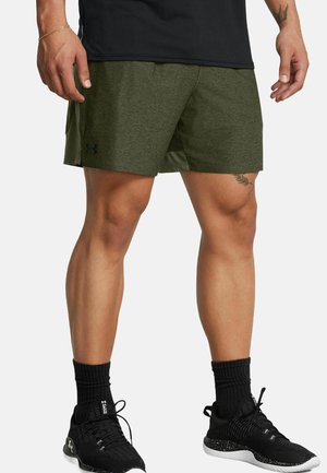 Shorts de sport vert olive avec une texture lisse, panneaux latéraux en mesh et un petit logo noir. Associés à des baskets noires texturées et des chaussettes côtelées.