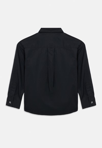 Μαύρο πουκάμισο με μακριά μανίκια και στάνταρ γιακά, πτυχώσεις στην πλάτη, μανσέτες με κουμπιά και λεία υφή υφάσματος. Μινιμαλιστικός σχεδιασμός χωρίς ορατά λογότυπα.