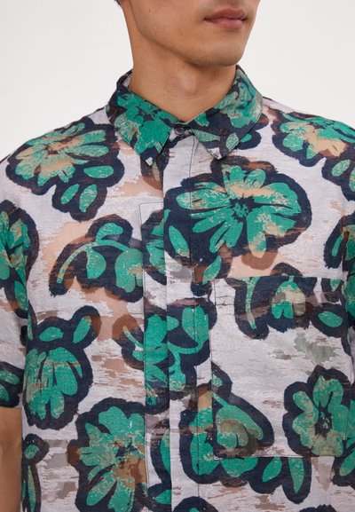 Short-sleeve shirt in sheer fabric with a floral pattern. Dominant colors are green and navy, featuring a chest pocket and button-up collar.