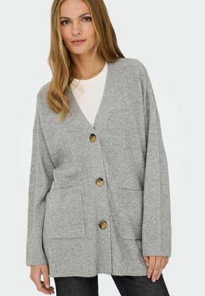 Cardigan gris à côtes avec un col en V, trois boutons sur le devant et deux poches sur le devant. Texture douce, coupe décontractée et manches longues.