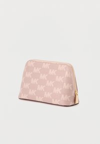 Pequeno estojo cosmético cor de rosa claro, com padrão repetido do logo "MK" e fecho dourado, colocado sobre uma superfície branca.