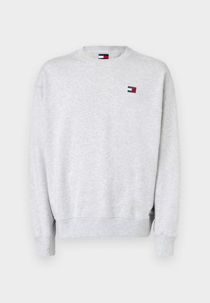 Lys grå langermet sweatshirt med ribbestrikkede mansjetter og nederkant, med et lite Tommy Jeans-logo merke på brystet.
