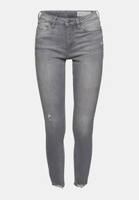 Vaqueros pitillo grises con detalles desgastados, con cierre de botones, trabillas para cinturón y dobladillo deshilachado. Fabricados con tela vaquera.