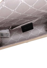 Interior de bolso color beige claro con forro gris estampado, un pequeño bolsillo interior y una etiqueta negra cosida en el interior.