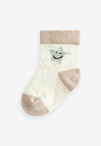 Bomuldssok i creme med en lysebrun ribbet manchet. Har et smilende stjernedesign i grøn og sort. Let tekstureret, rund tå.